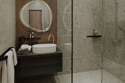 Executive room bathroom with glass-walled shower, elegant sink, and designer mirror.